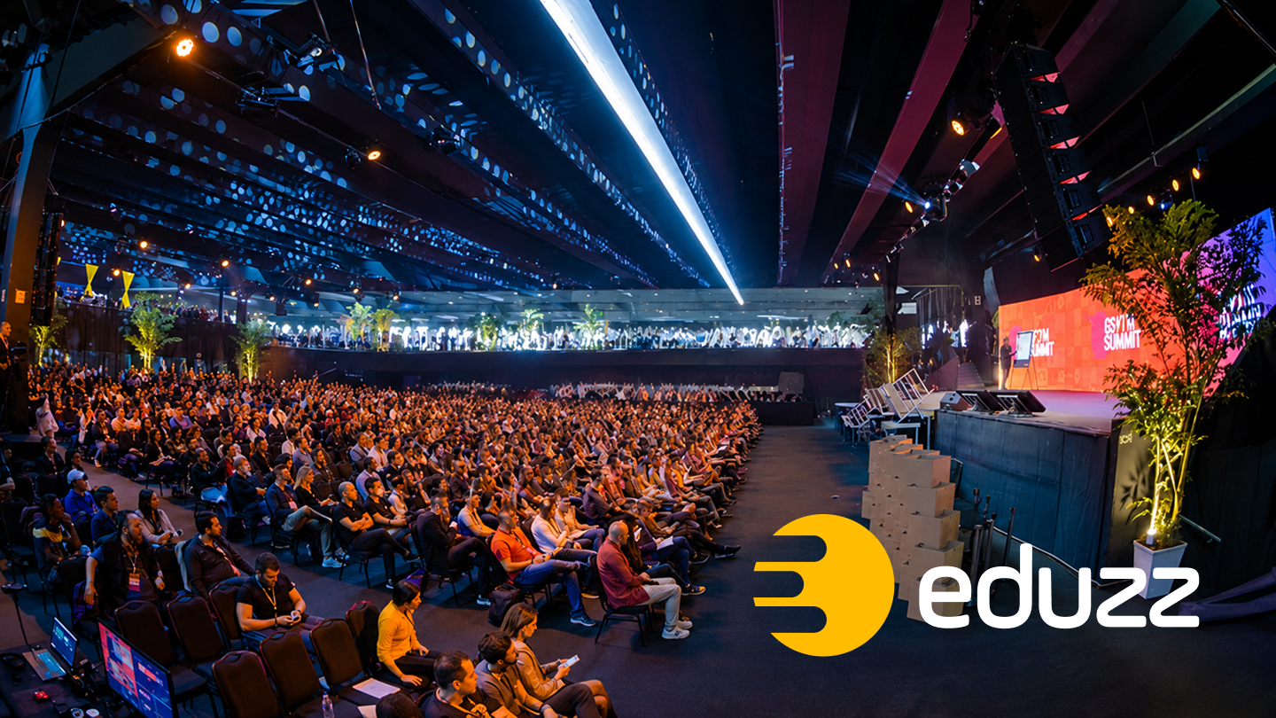 Plateia lotada no Ecom Summit, evento da Eduzz, com o palco ao fundo — ilustrando a escala da empresa por trás do portfólio de produtos